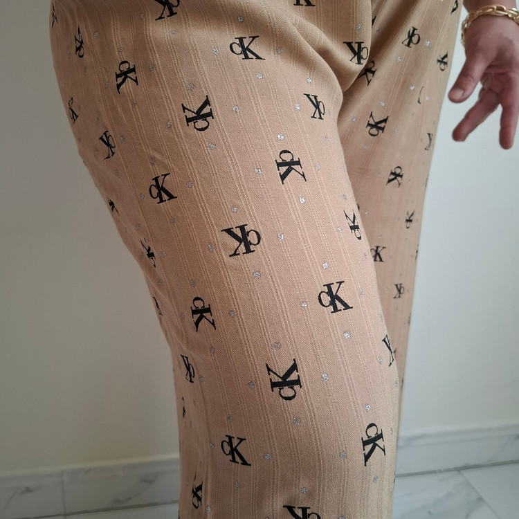 مای نزدیک طرح CK نقرهکوب روی شلوار نخی شکلاتی روشن