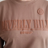 نمای نزدیک چاپ برجسته و پفکی Beverly Hills روی تیشرت زنانه شکلاتی